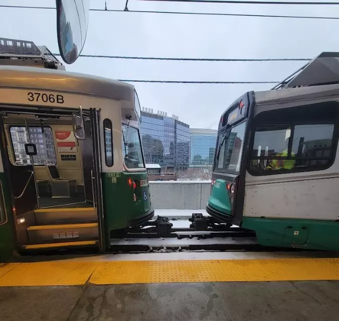 two green line trains facing each other just inches apart